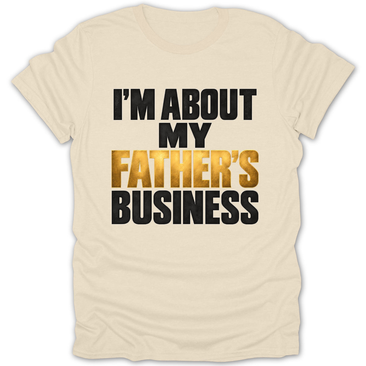 Cream t-shirt with black and gold text reading "I'M ABOUT MY FATHER'S BUSINESS".
