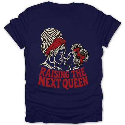 A navy blue t-shirt printed with a graphic of a Black mother and daughter, and the text RAISING THE NEXT QUEEN.