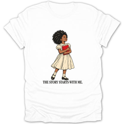 White t-shirt with a drawing of a girl holding a red book and the text "THE STORY STARTS WITH ME."