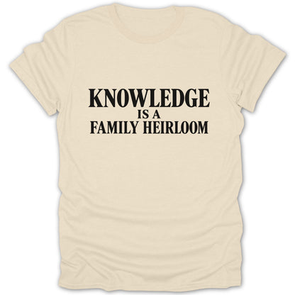 Cream-colored t-shirt with the black serif text KNOWLEDGE IS A FAMILY HEIRLOOM centered on the chest.