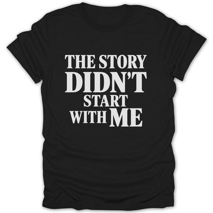 A black short-sleeved t-shirt features the white text THE STORY DIDN'T START WITH ME across the chest.