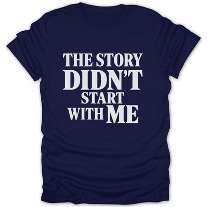 A dark blue t-shirt with white text that reads "THE STORY DIDN'T START WITH ME" centered on the chest.