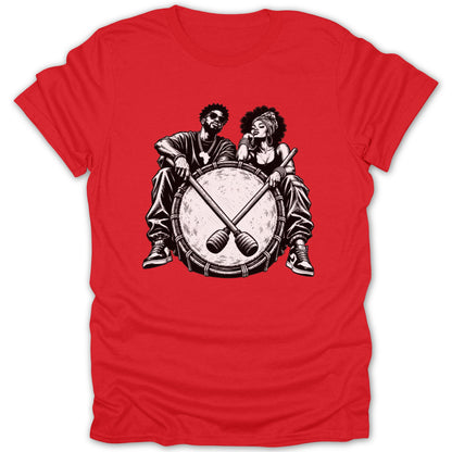 Two people sit behind a large drum with crossed drumsticks.