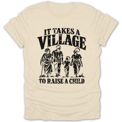 A cream-colored t-shirt featuring black distressed text that reads "IT TAKES A VILLAGE TO RAISE A CHILD" above and below an illustration of four people walking together.
