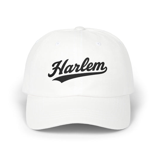 White baseball cap with "Harlem" in black script lettering.