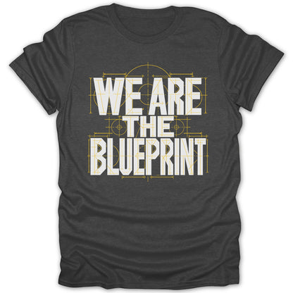Dark gray t-shirt with white text "WE ARE THE BLUEPRINT" over a blueprint design.