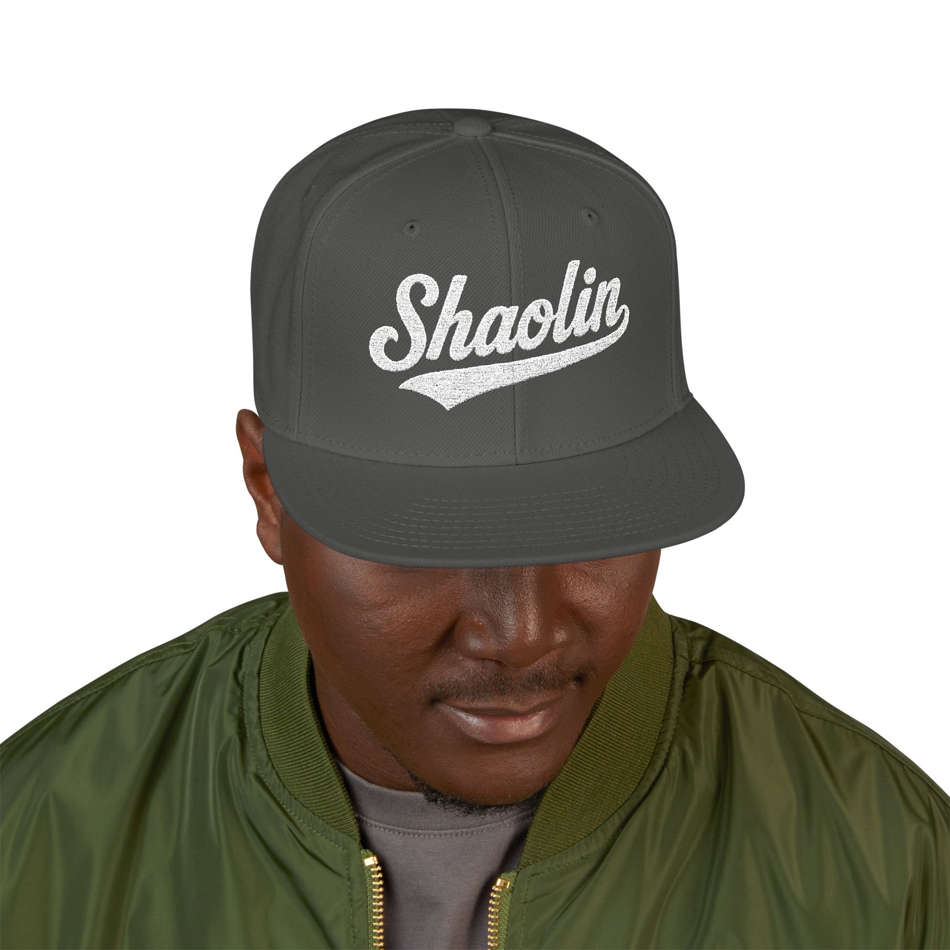 Dark grey snapback hat with "Shaolin" text, worn by a man.