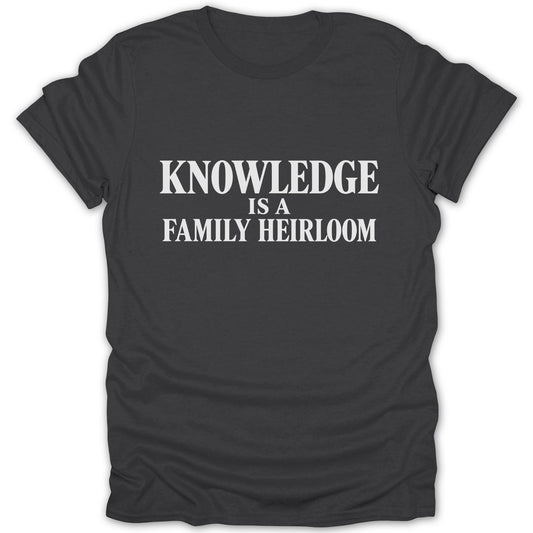 A dark gray crewneck t-shirt featuring the white text KNOWLEDGE IS A FAMILY HEIRLOOM centered on the chest.