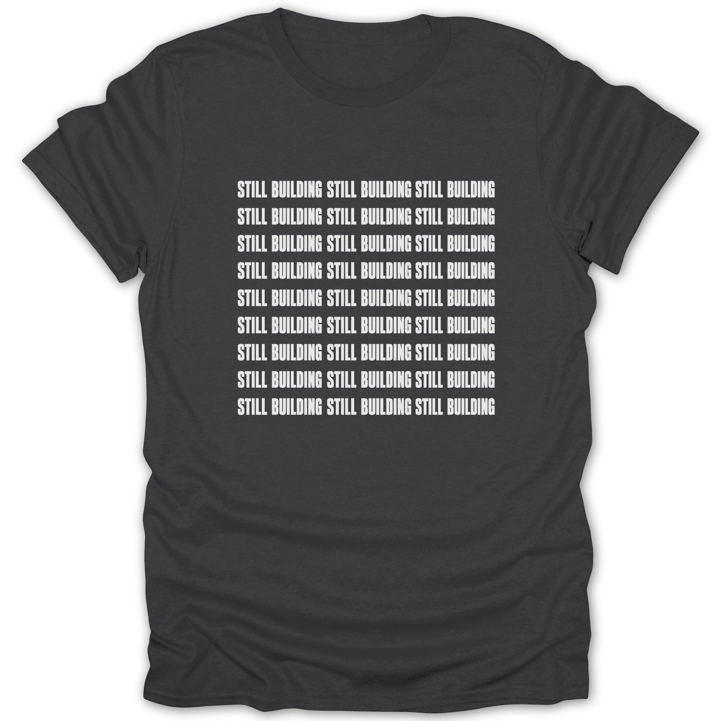 Dark grey t-shirt with white text repeating "Still Building" in rows.