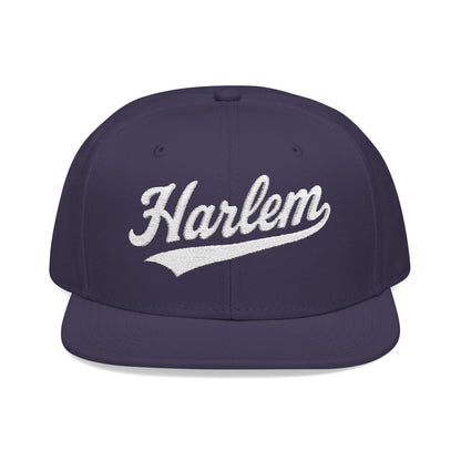 Purple snapback hat with "Harlem" embroidered in white script.
