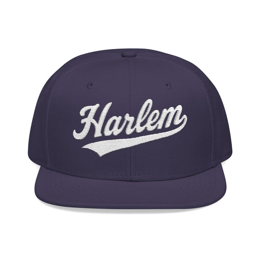 Purple snapback hat with "Harlem" embroidered in white script.