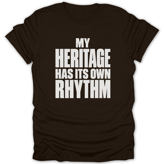 A dark brown short-sleeved t-shirt features white text reading MY HERITAGE HAS ITS OWN RHYTHM across the chest.
