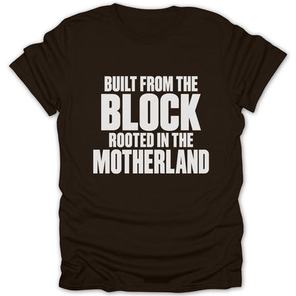 A dark brown short-sleeved t-shirt featuring white text that reads BUILT FROM THE BLOCK ROOTED IN THE MOTHERLAND.