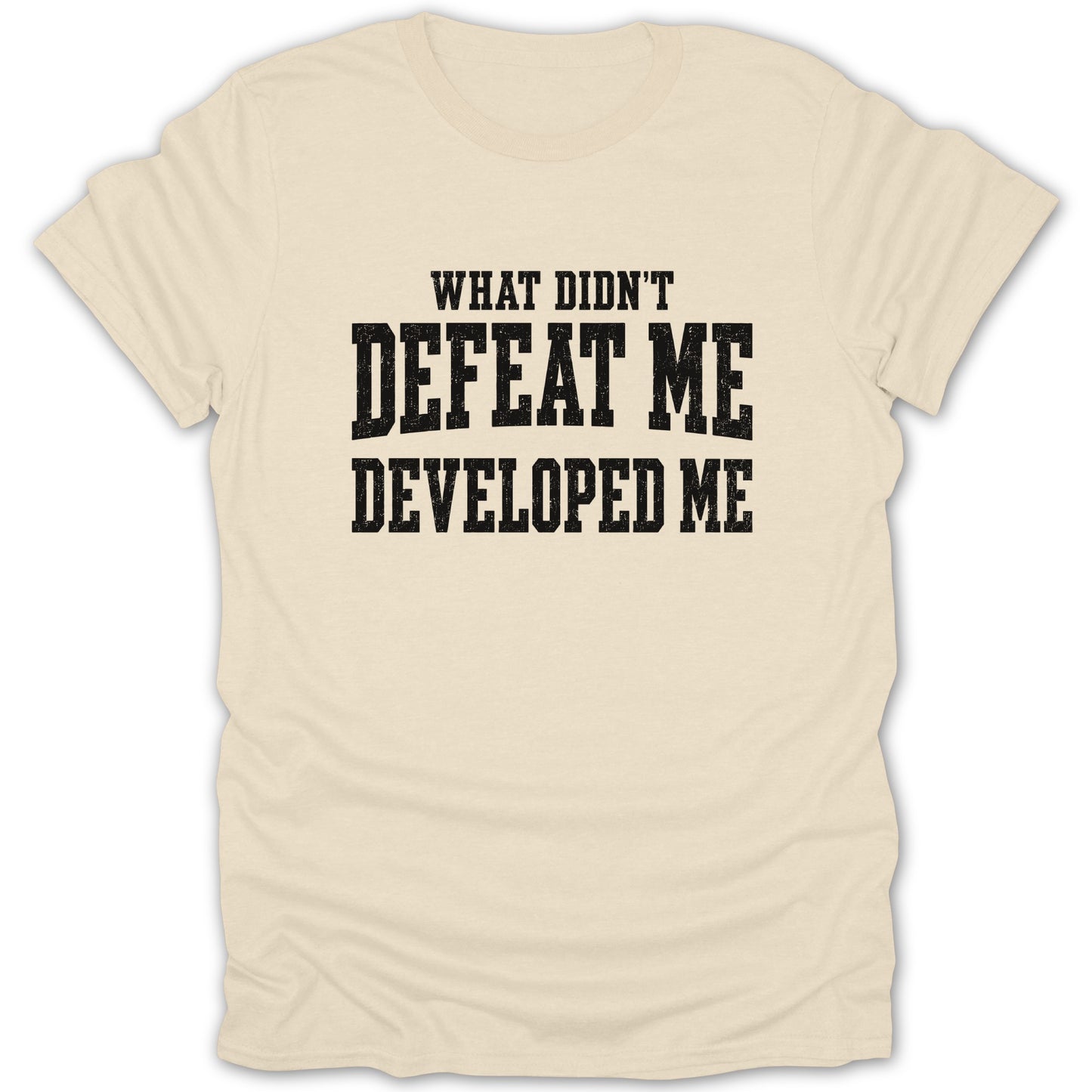 Cream t-shirt with black text that reads "WHAT DIDN'T DEFEAT ME DEVELOPED ME"