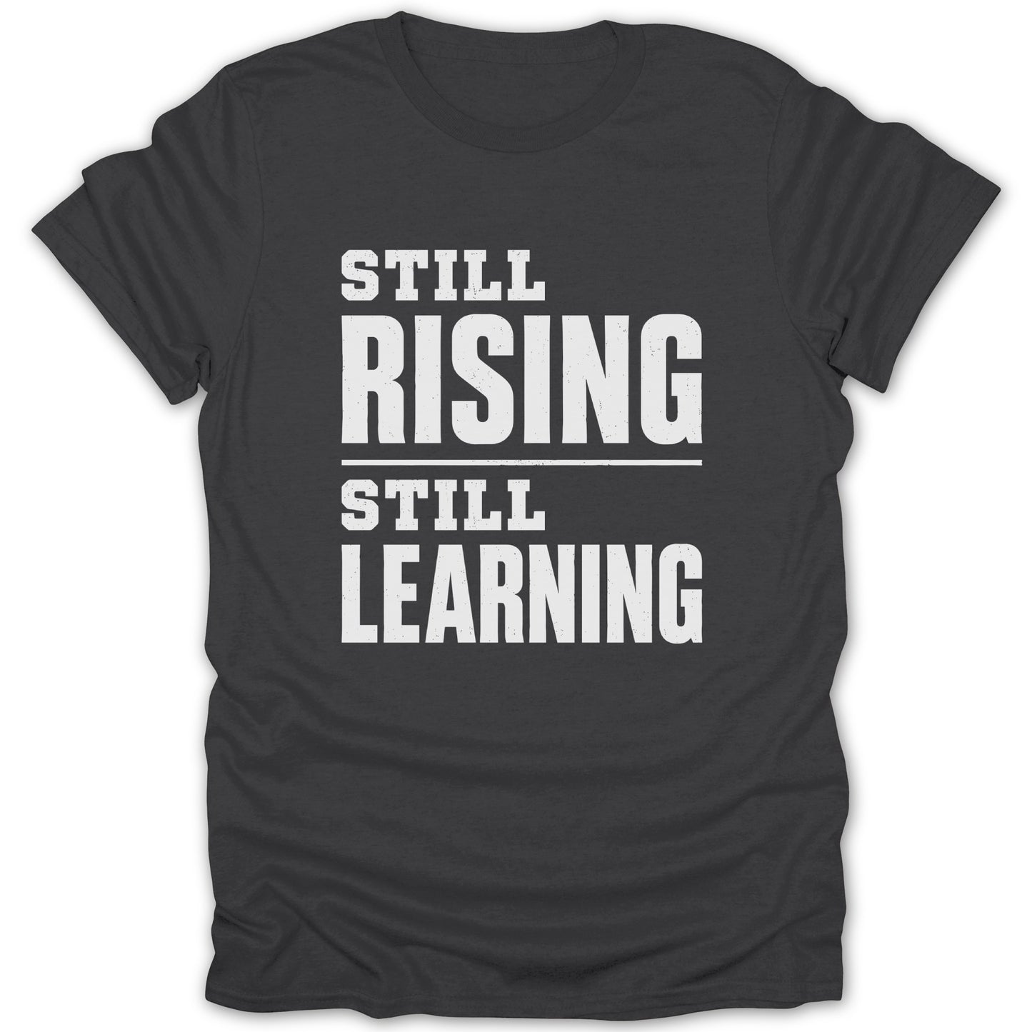 Dark t-shirt with white text "STILL RISING STILL LEARNING"