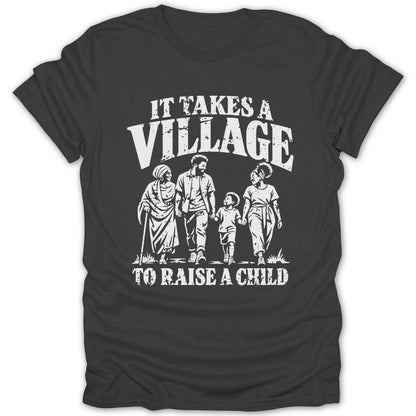 A dark gray t-shirt featuring the white graphic text It takes a village to raise a child and an illustration of a multigenerational family walking together.