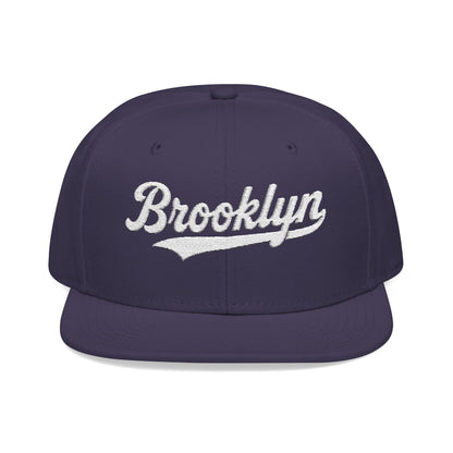 Purple snapback hat with "Brooklyn" embroidered in white script.