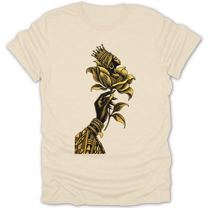Black hand holding golden flower with profile of crowned Black woman, on beige t-shirt.