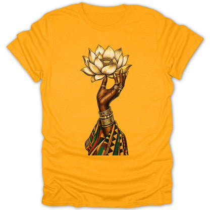 Hand holding golden lotus with rings and bracelets, on yellow t-shirt.