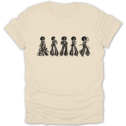 Five women with afros in disco-inspired outfits are printed on a cream t-shirt.