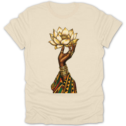 Black hand holding golden lotus with ornate jewelry and patterned fabric.