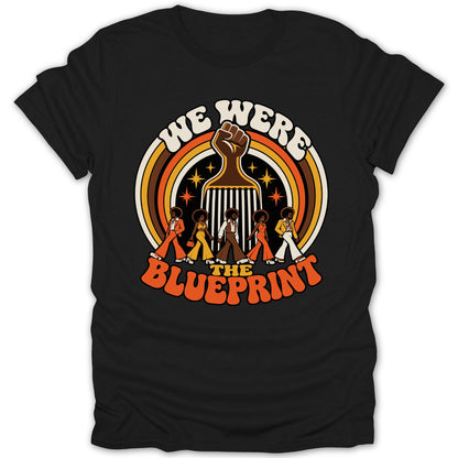 "We Were The Blueprint" text with retro figures and raised fist on black t-shirt.