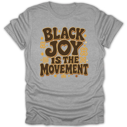 Gray t-shirt with bold brown text: "BLACK JOY IS THE MOVEMENT".