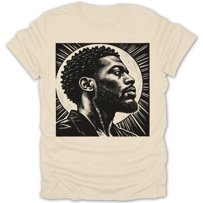 Black and white linocut art of a man with afro and beard on a light cream t-shirt.