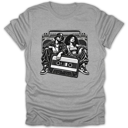 Black and white illustration of a couple and boombox with cassette tape on gray t-shirt.