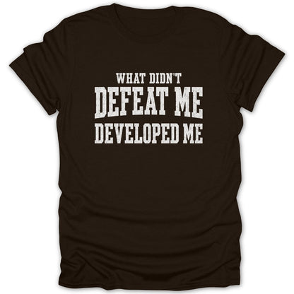 Brown t-shirt with white text reading "WHAT DIDN'T DEFEAT ME DEVELOPED ME".