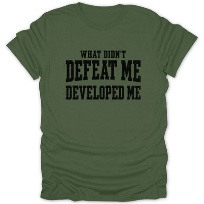 Olive green t-shirt with black text "WHAT DIDN'T DEFEAT ME DEVELOPED ME"