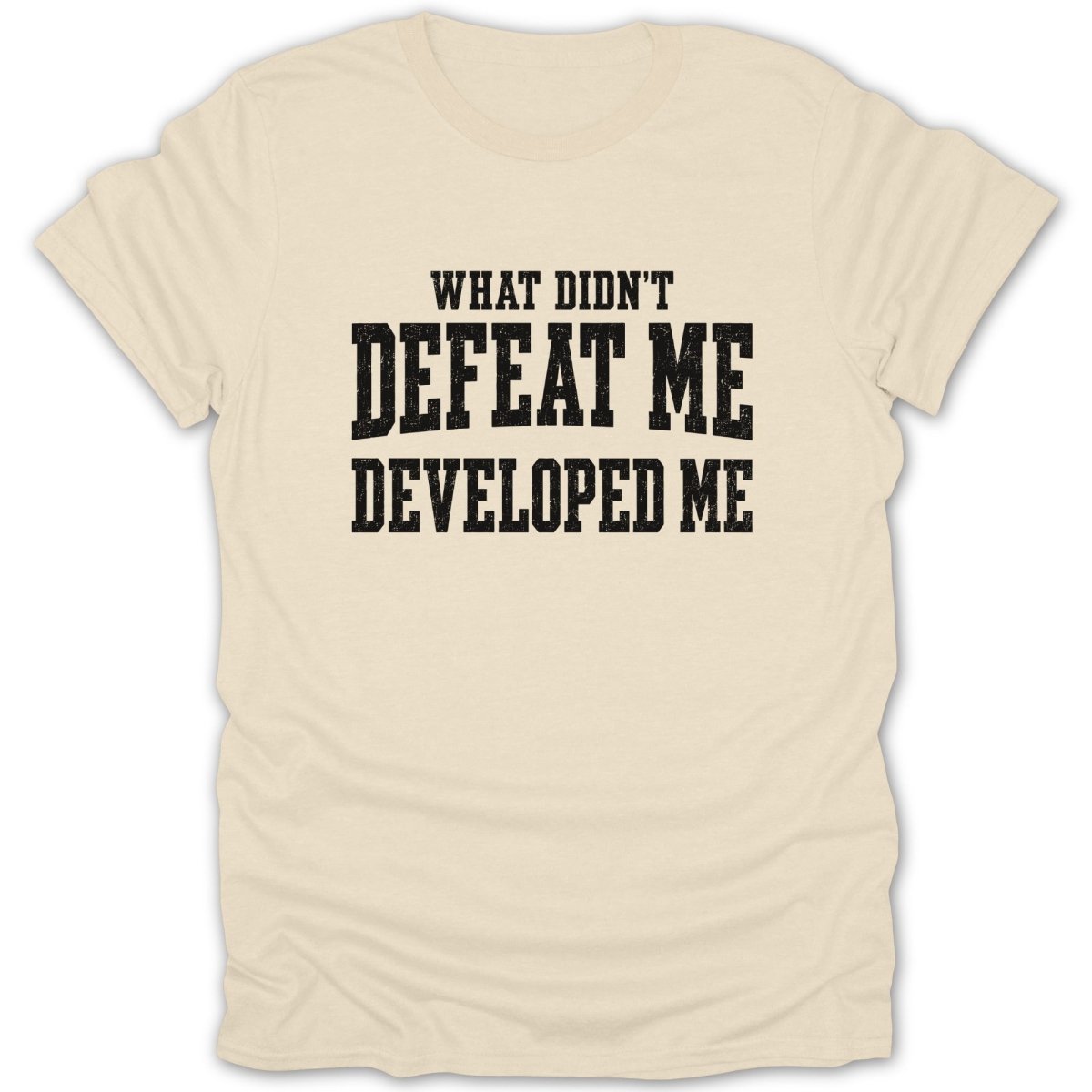 Cream t-shirt with black text that reads "WHAT DIDN'T DEFEAT ME DEVELOPED ME"
