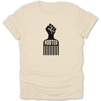 A cream-colored short-sleeved t-shirt featuring a black graphic of an afro pick combined with a raised fist and the text ROOTED.