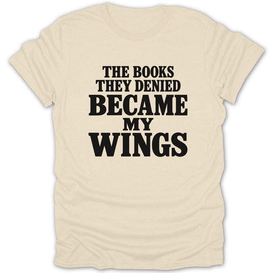 A cream-colored t-shirt with centered black text reading The books they denied became my wings.