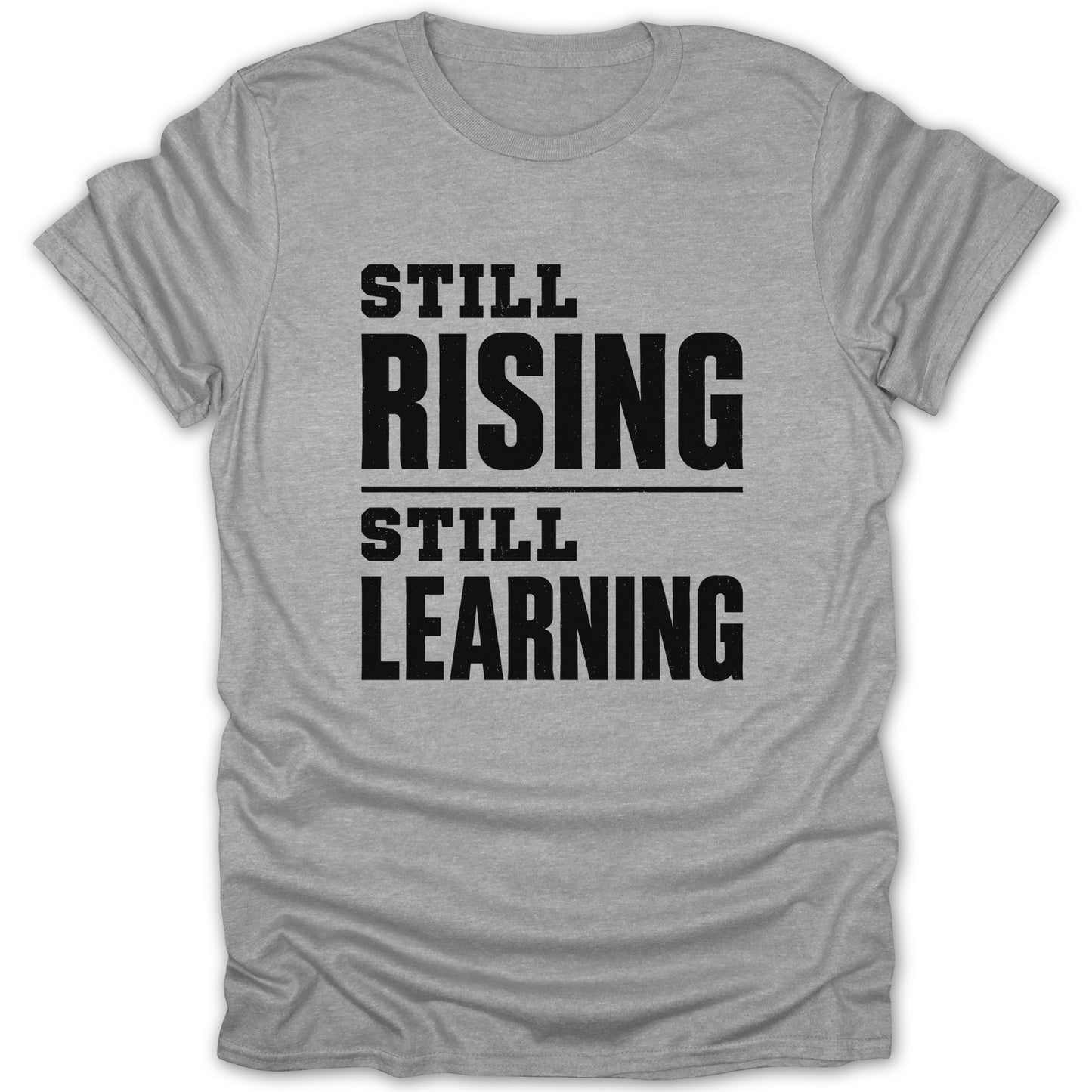 Grey t-shirt with black text reading "STILL RISING STILL LEARNING".