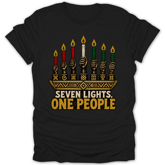 Black t-shirt featuring a kinara graphic with seven lit candles, African-inspired symbols, and the text SEVEN LIGHTS, ONE PEOPLE.