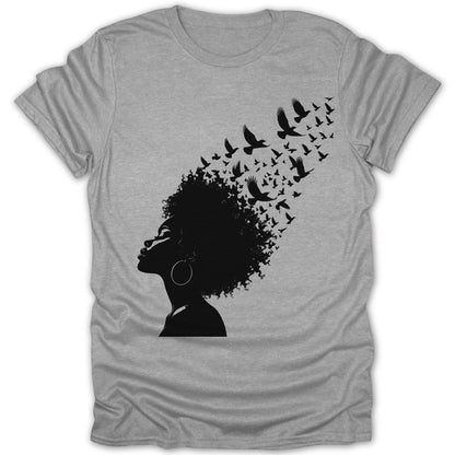 Black silhouette of woman with birds flying from her hair on grey t-shirt.