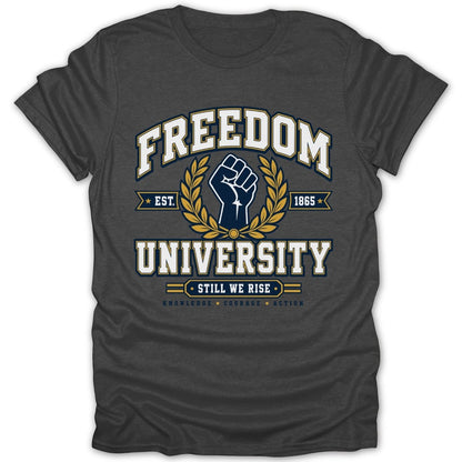 Dark gray t-shirt with "FREEDOM UNIVERSITY" text, a raised fist, laurel branches, and "STILL WE RISE".