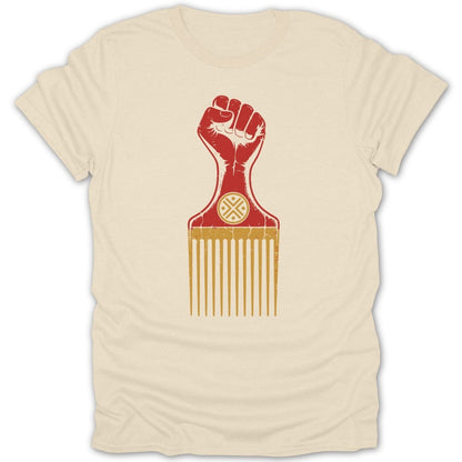 Fist-shaped hair pick with circular symbol on cream t-shirt.