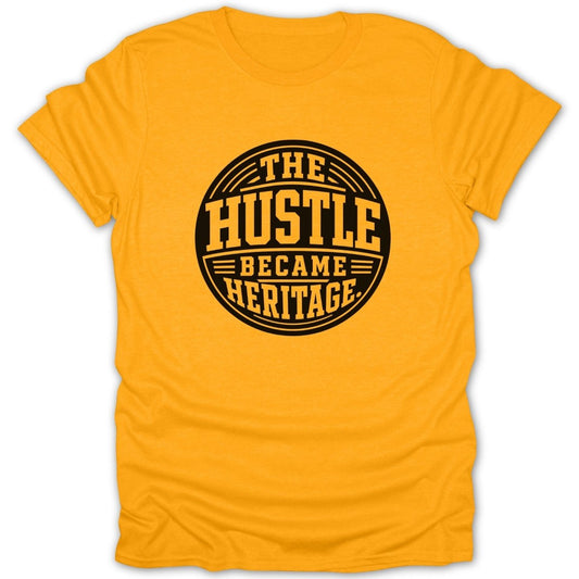 Yellow t-shirt with black text reading "THE HUSTLE BECAME HERITAGE" in a circle.