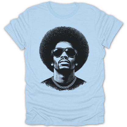 Black and white portrait of a man with an afro and sunglasses on a light blue t-shirt.