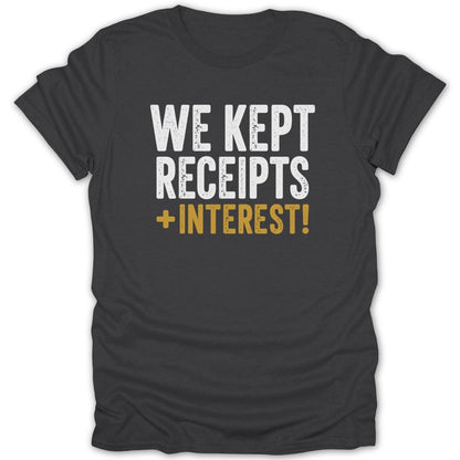 Dark grey t-shirt with white and gold text reading "WE KEPT RECEIPTS + INTEREST!"