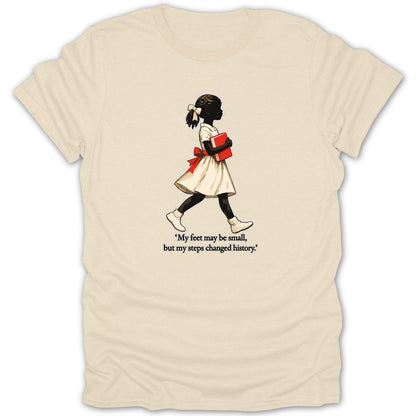 T-shirt with graphic of young girl holding a book and quote, "My feet may be small, but my steps changed history."