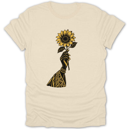 Black hand holding a sunflower with tribal pattern on forearm.