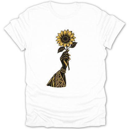 Black hand holding a yellow sunflower with tribal patterned sleeve on white t-shirt.