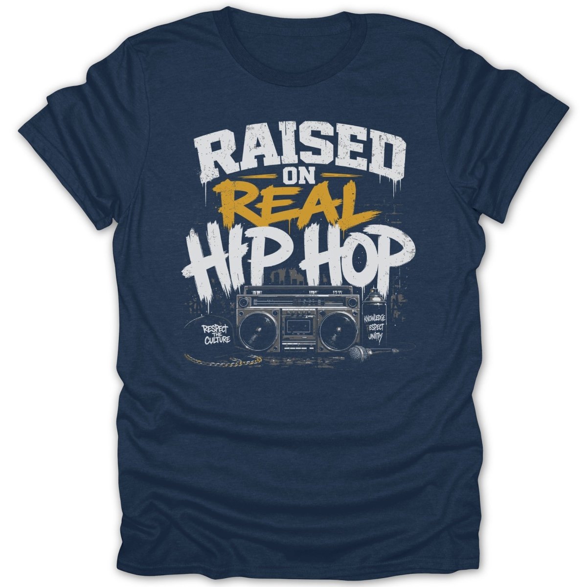 Dark blue t-shirt graphic with "Raised On Real Hip Hop" text, boombox, microphone, and spray can.