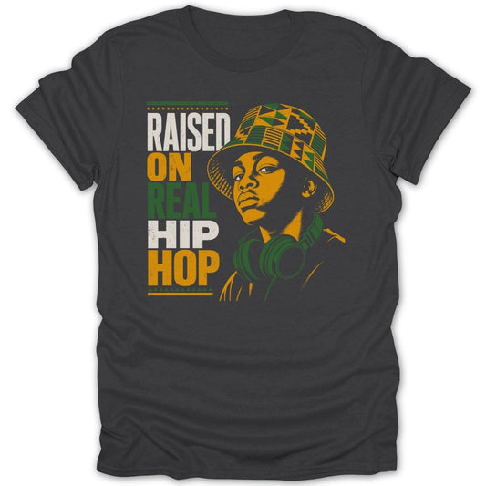 Dark t-shirt with text "RAISED ON REAL HIP HOP" and graphic of a person wearing a bucket hat and headphones.
