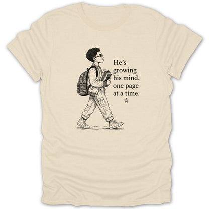 T-shirt with sketch of boy holding books and text "He's growing his mind, one page at a time."