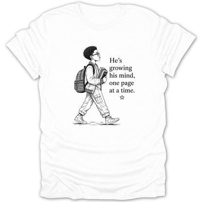 White t-shirt with drawing of a boy with glasses and backpack, carrying books and text.