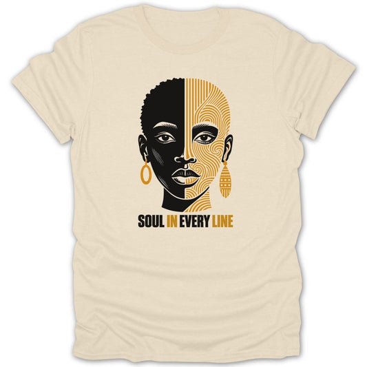 Cream t-shirt with abstract black and gold face design and "SOUL IN EVERY LINE" text.